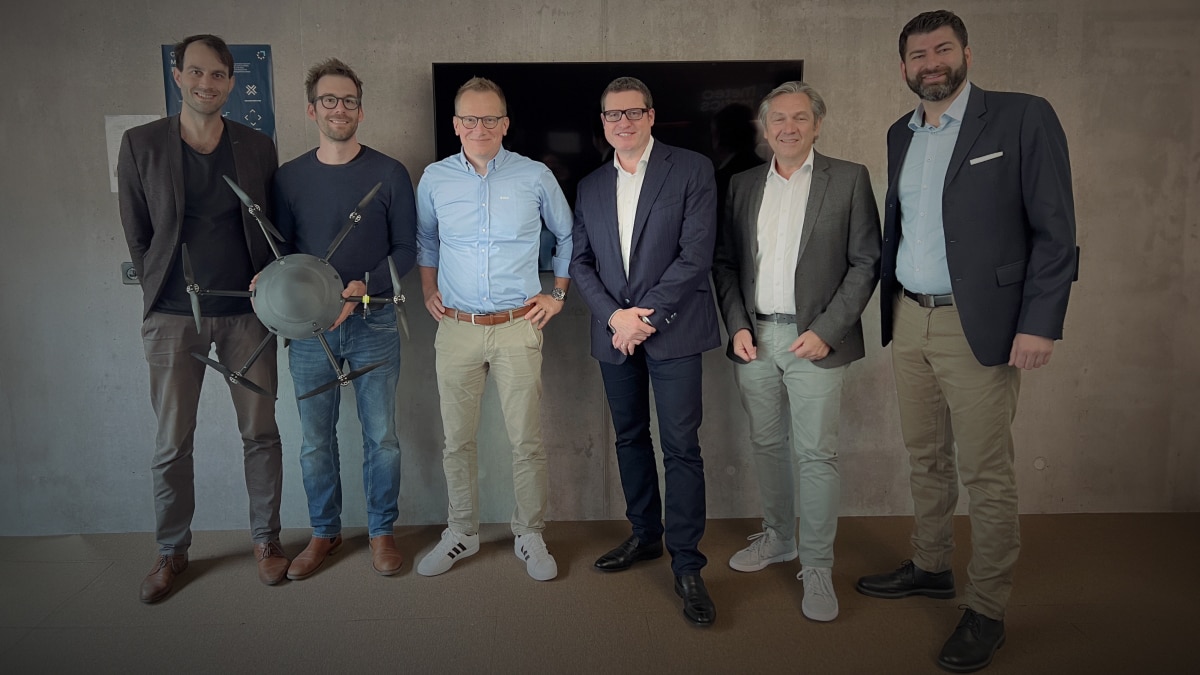 Group of researchers holding a drone posing.