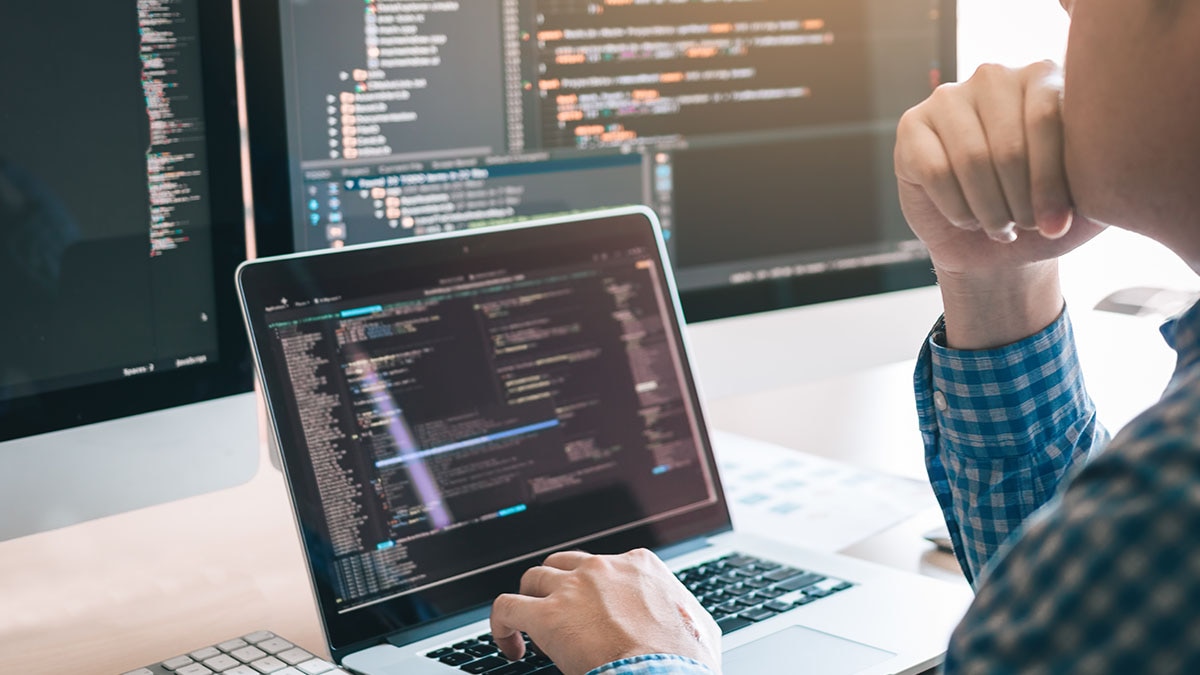 Free Software Person sitting working on code on laptop screens