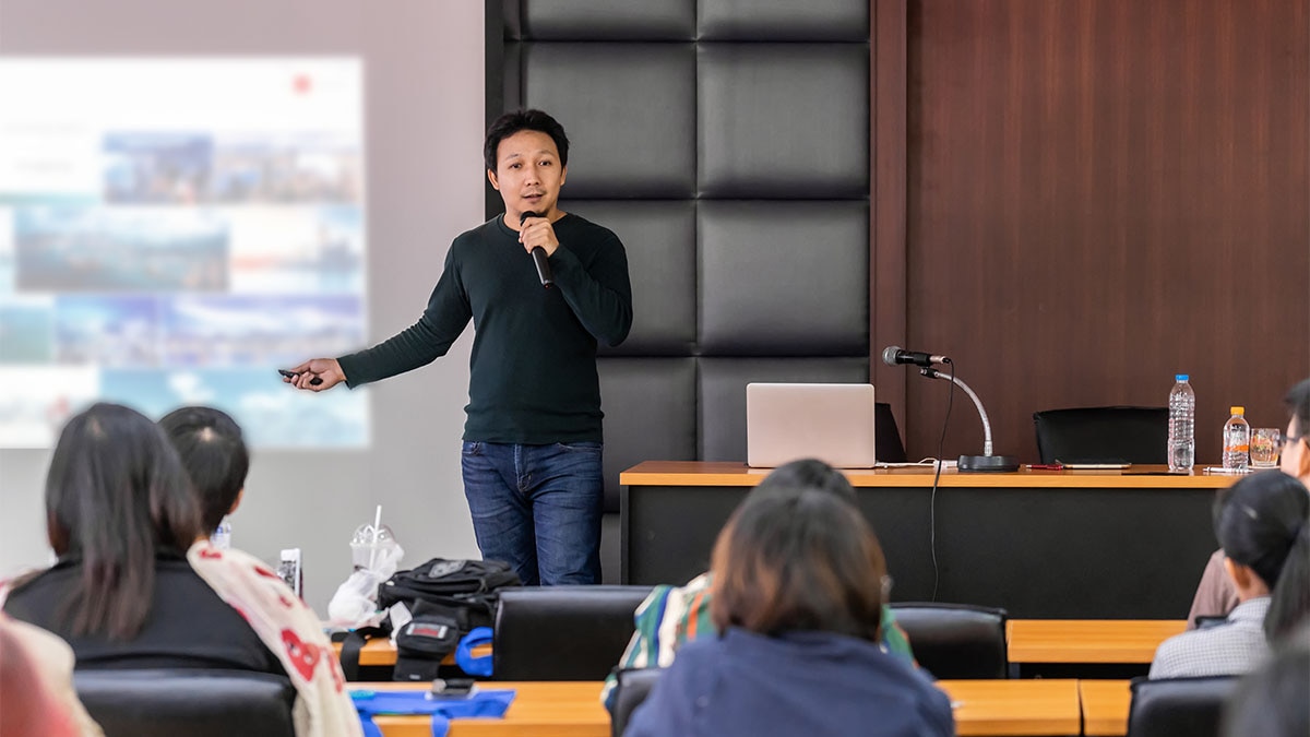 Training Man holding microphone in front of students
